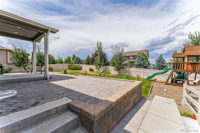 view of patio featuring a fenced backyard and a playground