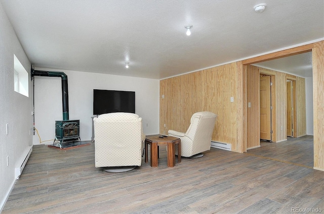 18340 S Lake Rd, Buena Vista, CO 81211 - unfurnished room with a baseboard radiator, a wood stove, a baseboard heating unit, and wood finished floors