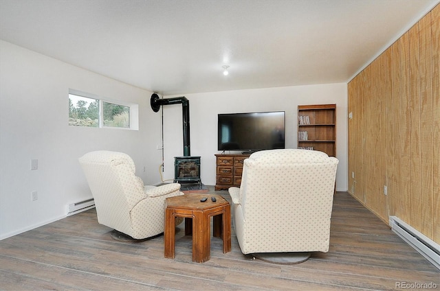 18340 S Lake Rd, Buena Vista, CO 81211 - living area featuring a baseboard heating unit, a wood stove, wood finished floors, and wooden walls