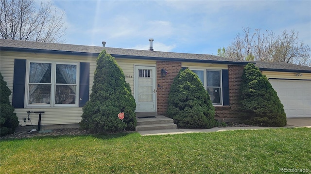 view of front facade with an attached garage, brick siding, and a front yard
