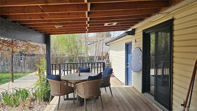 deck with a fenced backyard and outdoor dining area