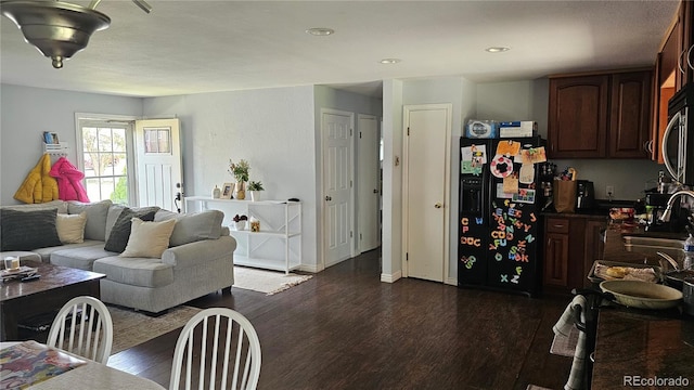 living room featuring dark wood-type flooring, recessed lighting, and baseboards