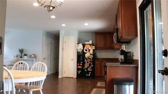 kitchen featuring recessed lighting, brown cabinets, black refrigerator with ice dispenser, and a notable chandelier