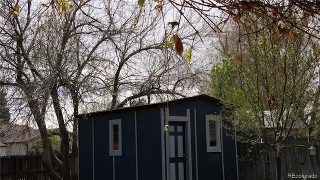 view of shed featuring fence