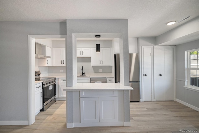 7165 S Gaylord St Unit H05, Centennial, CO 80122 - kitchen featuring appliances with stainless steel finishes, light wood-type flooring, white cabinetry, light countertops, and a textured ceiling