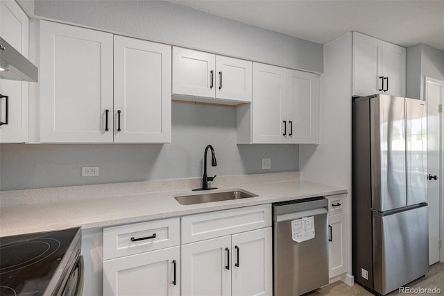 7165 S Gaylord St Unit H05, Centennial, CO 80122 - kitchen with stainless steel appliances, white cabinetry, and wall chimney exhaust hood
