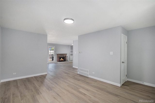 7165 S Gaylord St Unit H05, Centennial, CO 80122 - unfurnished living room with wood finished floors and a brick fireplace