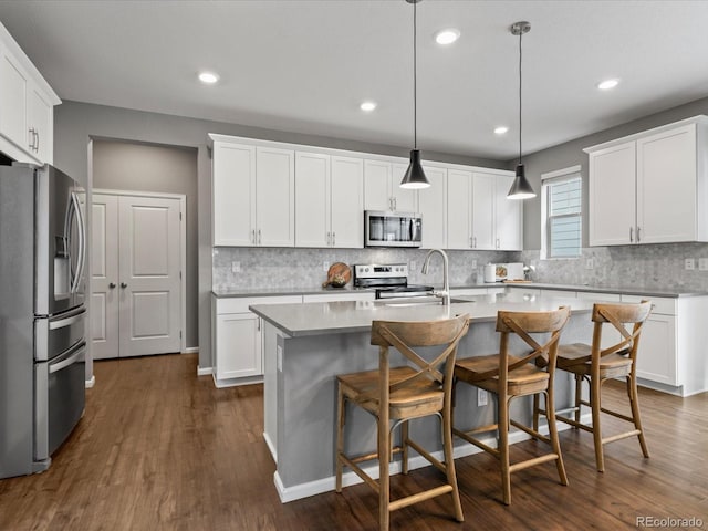 5716 Boston Ct, Denver, CO 80238 - kitchen with stainless steel appliances, backsplash, dark wood-style floors, a center island with sink, and recessed lighting