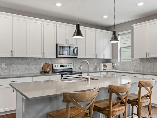 5716 Boston Ct, Denver, CO 80238 - kitchen with stainless steel appliances, a sink, an island with sink, a kitchen breakfast bar, and recessed lighting