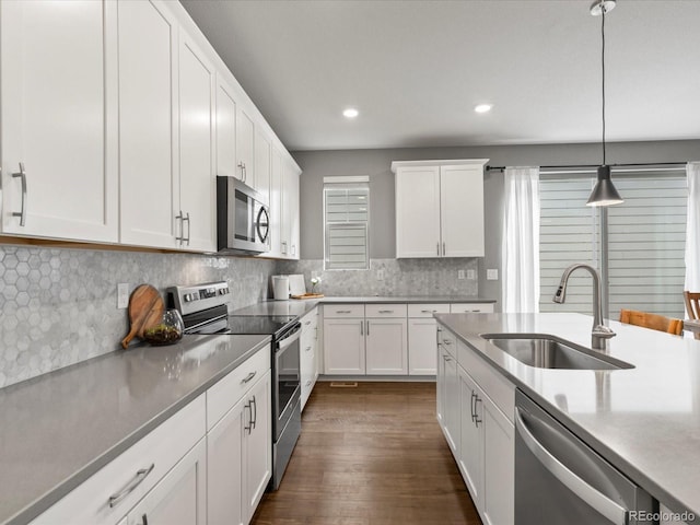5716 Boston Ct, Denver, CO 80238 - kitchen with stainless steel appliances, a sink, white cabinetry, hanging light fixtures, and recessed lighting