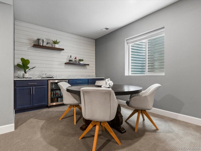 5716 Boston Ct, Denver, CO 80238 - dining room with beverage cooler, bar with sink, light colored carpet, baseboards, and wooden walls