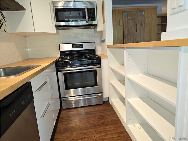 kitchen featuring wooden counters, white cabinets, tasteful backsplash, dark hardwood / wood-style flooring, and stainless steel appliances