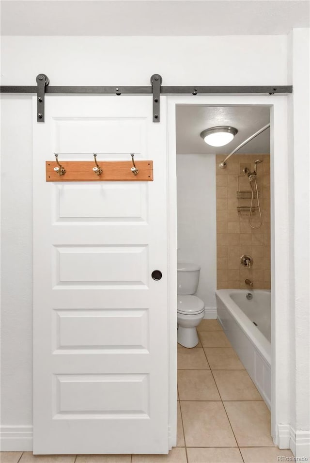 bathroom featuring tile patterned flooring, tiled shower / bath combo, and toilet