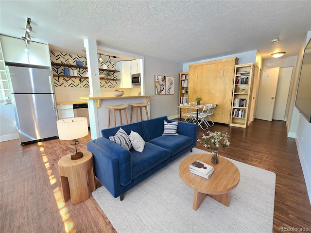 living room featuring dark wood-type flooring and a textured ceiling