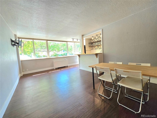 dining area featuring radiator, dark hardwood / wood-style flooring, and a textured ceiling