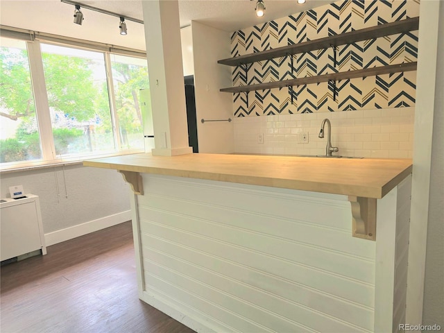 bar featuring wooden counters, radiator heating unit, dark hardwood / wood-style flooring, and sink