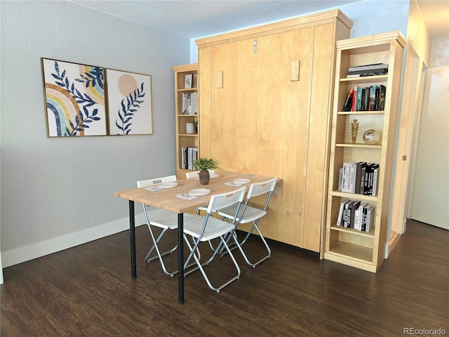 dining space with a textured ceiling and dark hardwood / wood-style floors