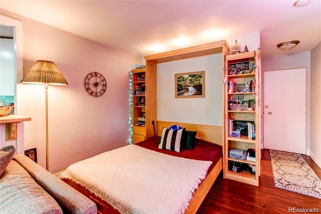 bedroom with dark wood-type flooring