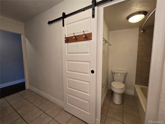 bathroom featuring tile patterned flooring, tiled shower / bath combo, and toilet