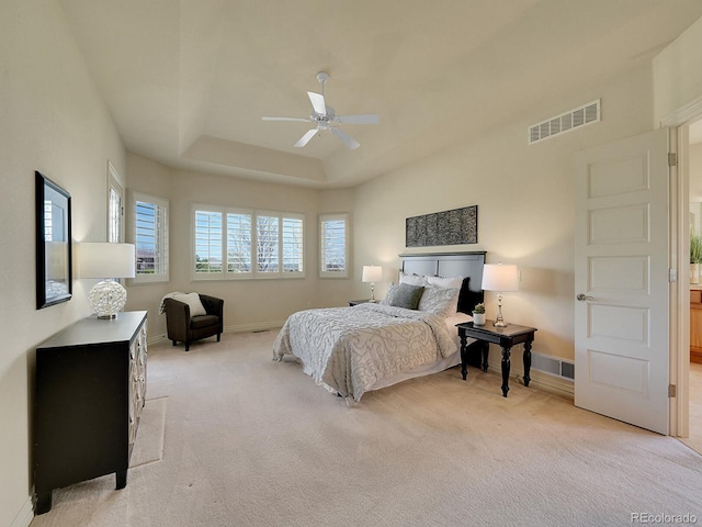 bedroom with light carpet, baseboards, ceiling fan, and a raised ceiling