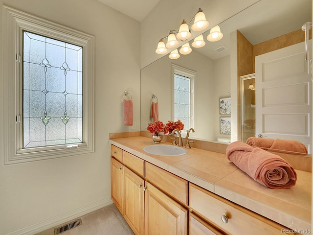 bathroom with vanity, a shower stall, and baseboards