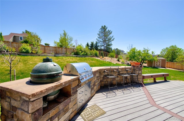 9688 Chesapeake St, Highlands Ranch, CO 80126 - wooden terrace featuring exterior kitchen, area for grilling, a shed, a fenced backyard, and a lawn