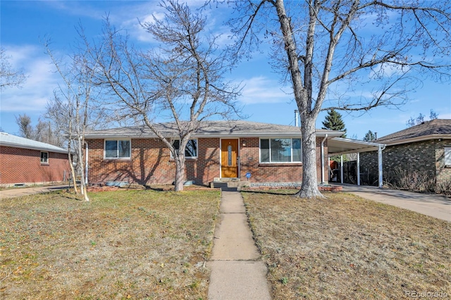 single story home featuring driveway, a front yard, a carport, and brick siding