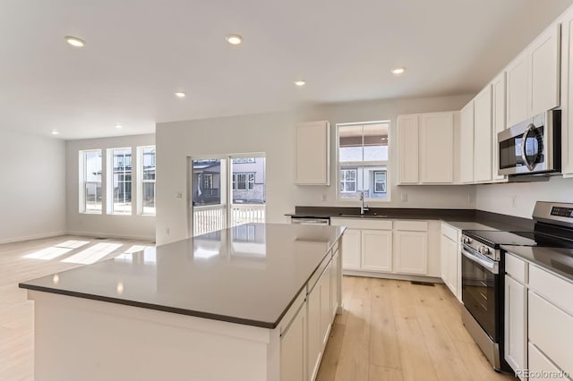 kitchen featuring dark countertops, recessed lighting, light wood-style floors, and appliances with stainless steel finishes