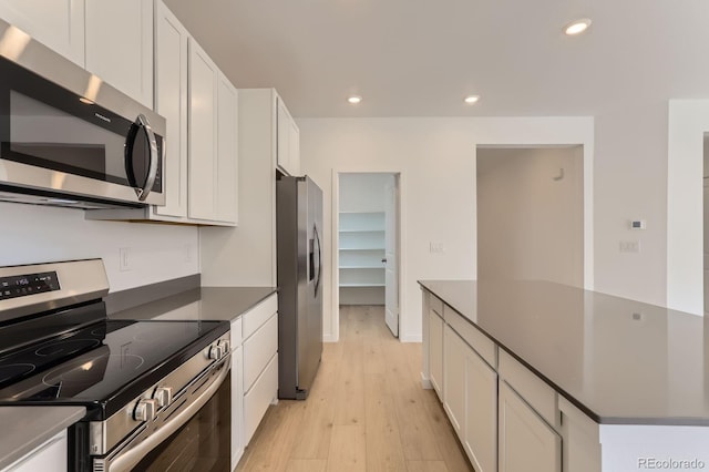 kitchen featuring dark countertops, recessed lighting, appliances with stainless steel finishes, white cabinets, and light wood finished floors