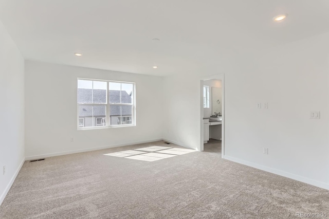 carpeted spare room featuring visible vents, recessed lighting, and baseboards