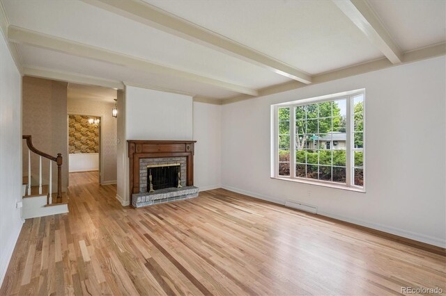 3225 S Race St, Englewood, CO 80113 - unfurnished living room featuring beamed ceiling, wood finished floors, a brick fireplace, and stairs