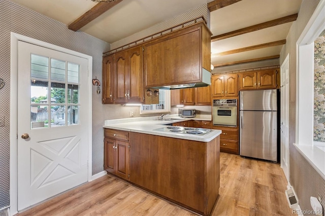 3225 S Race St, Englewood, CO 80113 - kitchen featuring stainless steel appliances, beam ceiling, brown cabinetry, light wood-style floors, and a peninsula