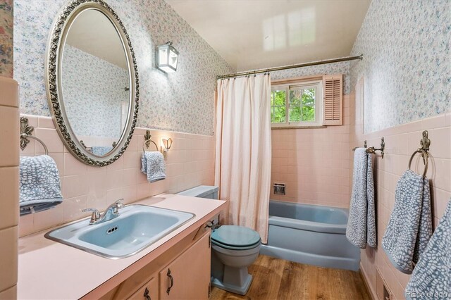 3225 S Race St, Englewood, CO 80113 - bathroom featuring tile walls, wallpapered walls, wood finished floors, vanity, and shower / bath combo