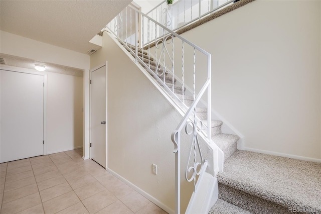 staircase featuring tile patterned flooring