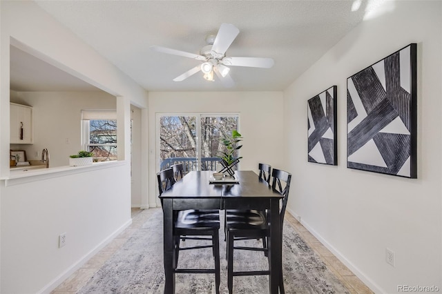 dining area with a textured ceiling and ceiling fan