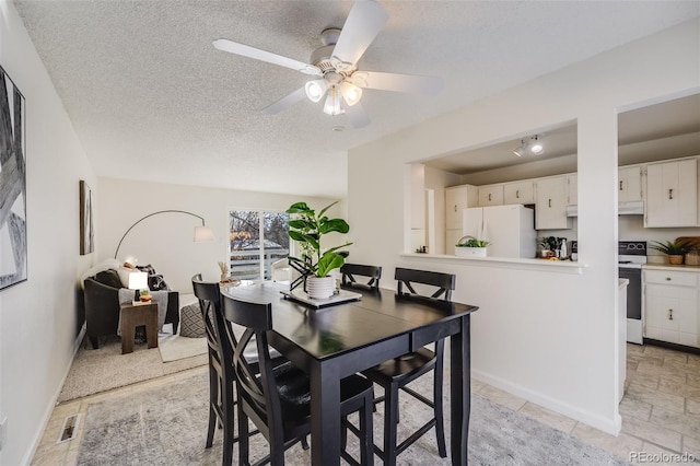 dining room featuring ceiling fan and a textured ceiling