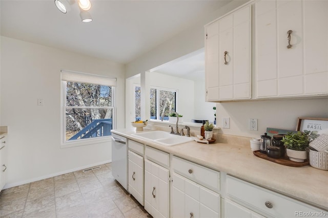 kitchen featuring dishwasher, sink, and white cabinets