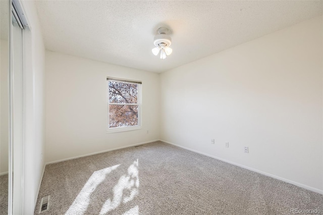 unfurnished room featuring carpet floors and a textured ceiling