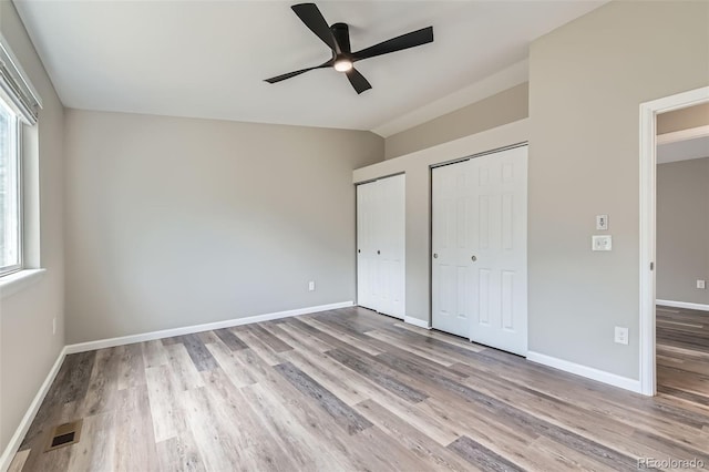 6040 W 75th Dr, Arvada, CO 80003 - unfurnished bedroom with two closets, light wood-style floors, lofted ceiling, and ceiling fan