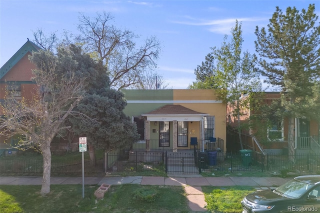 view of front of home with a fenced front yard, stucco siding, a gate, and covered porch