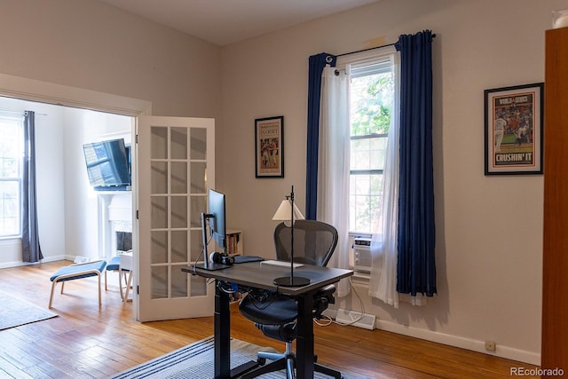 home office with cooling unit, light wood-style floors, and baseboards