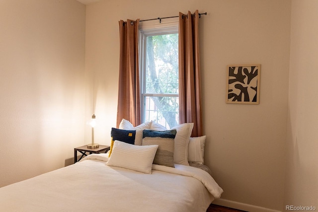 bedroom with baseboards and wood finished floors
