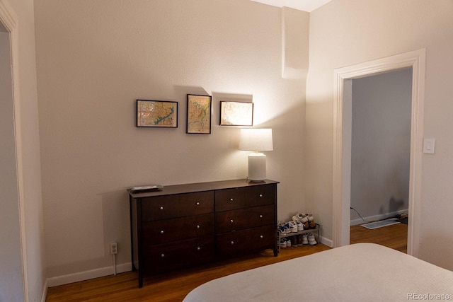 bedroom with dark wood-style flooring