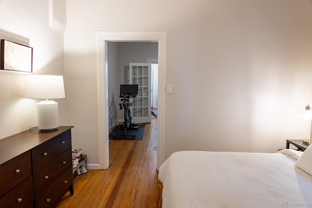 bedroom featuring baseboards and hardwood / wood-style flooring
