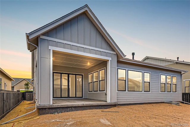 back house at dusk featuring central air condition unit and a patio