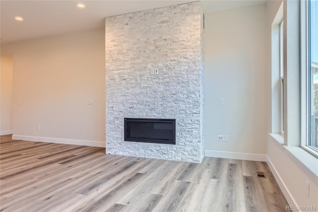 unfurnished living room featuring a fireplace and light wood-type flooring