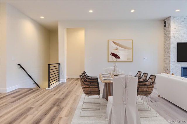 dining area with a fireplace and light hardwood / wood-style flooring