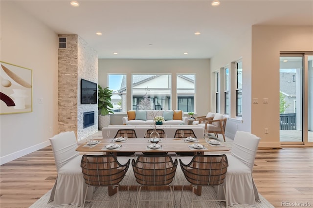 dining space featuring a fireplace and light hardwood / wood-style floors