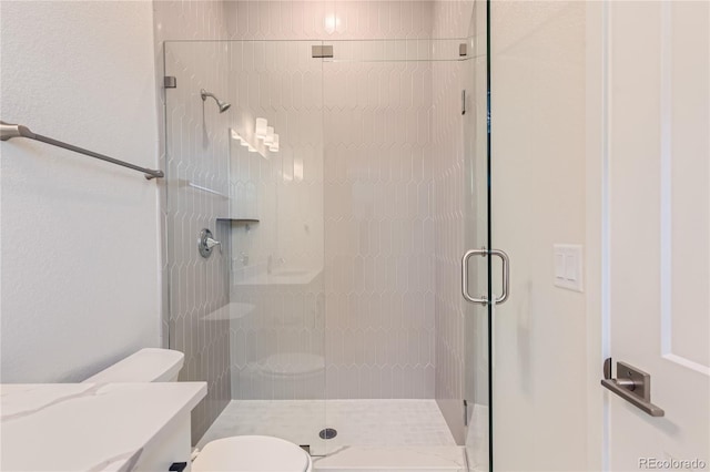 bathroom featuring toilet and an enclosed shower