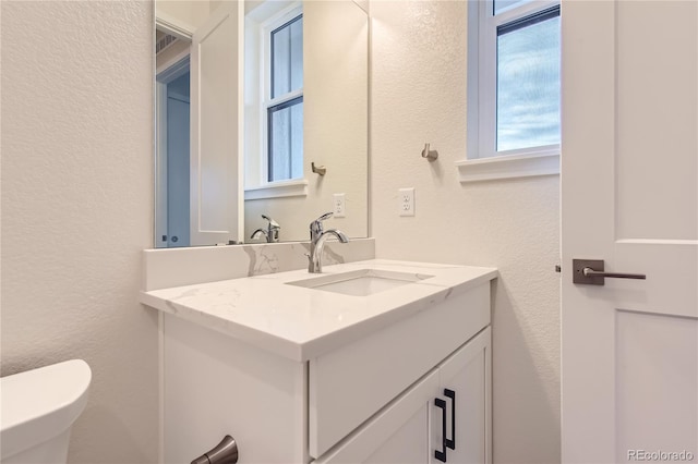 bathroom featuring vanity and toilet